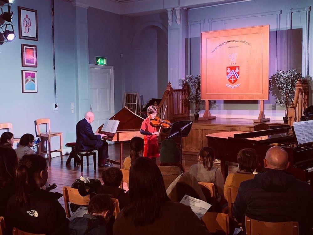 Boy playing violin accompanied by harpsichord